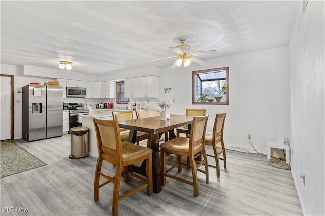 dining space featuring ceiling fan and light wood-type flooring