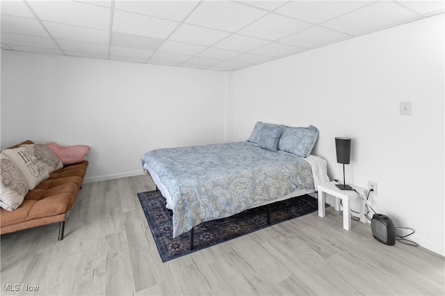 bedroom featuring light hardwood / wood-style floors and a drop ceiling