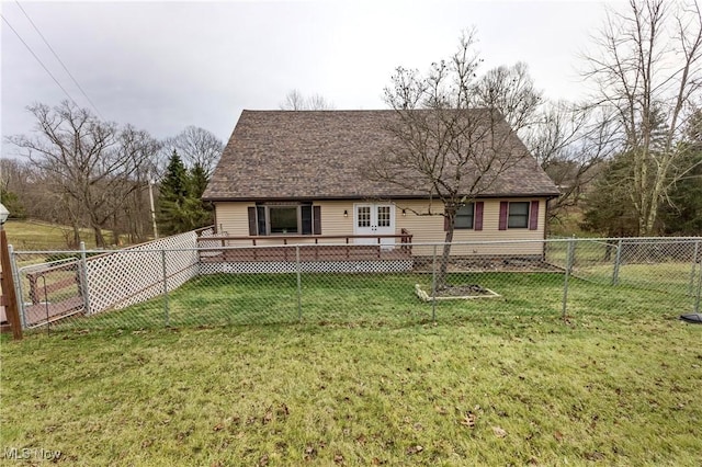 rear view of property featuring a wooden deck and a lawn