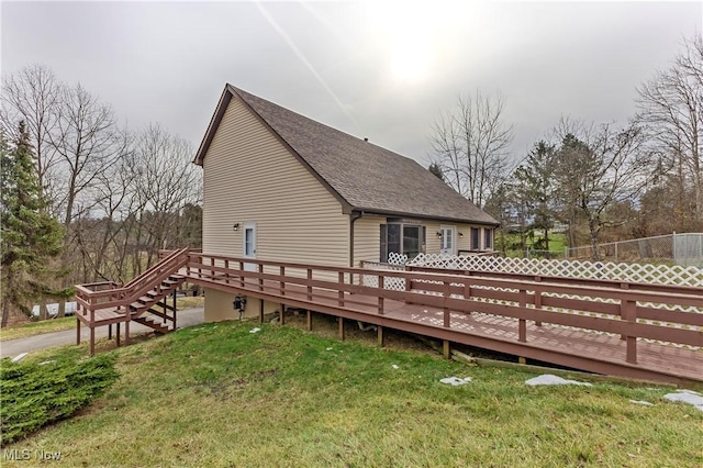 back of house featuring a wooden deck and a lawn