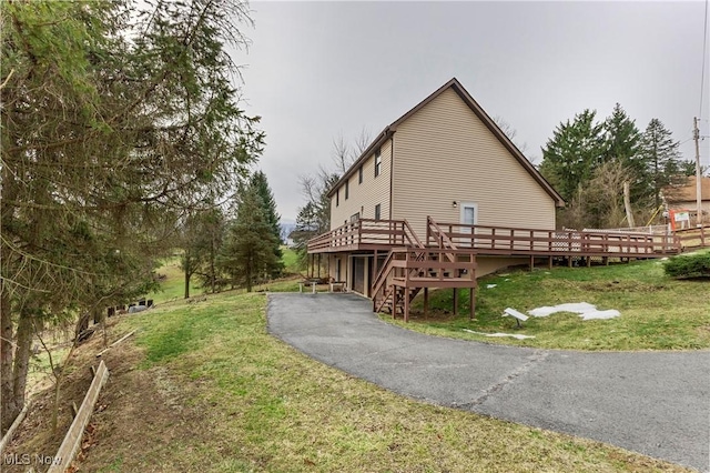 view of side of property featuring a wooden deck and a yard