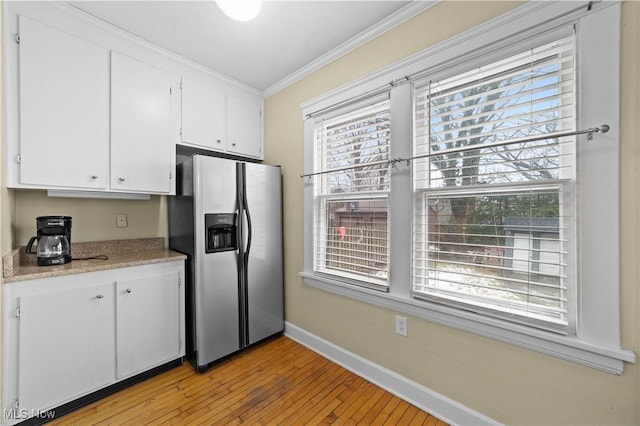 kitchen featuring crown molding, light hardwood / wood-style flooring, white cabinets, and stainless steel fridge with ice dispenser