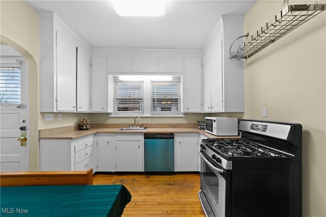 kitchen featuring white cabinetry, sink, stainless steel appliances, and light hardwood / wood-style floors