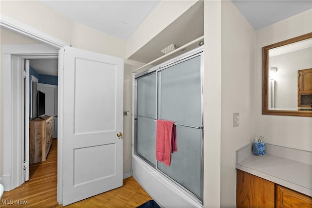 bathroom featuring bath / shower combo with glass door and hardwood / wood-style floors