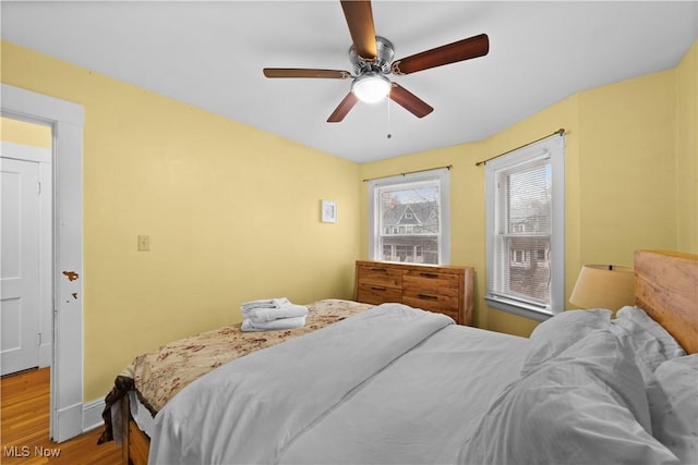 bedroom with ceiling fan and light hardwood / wood-style floors