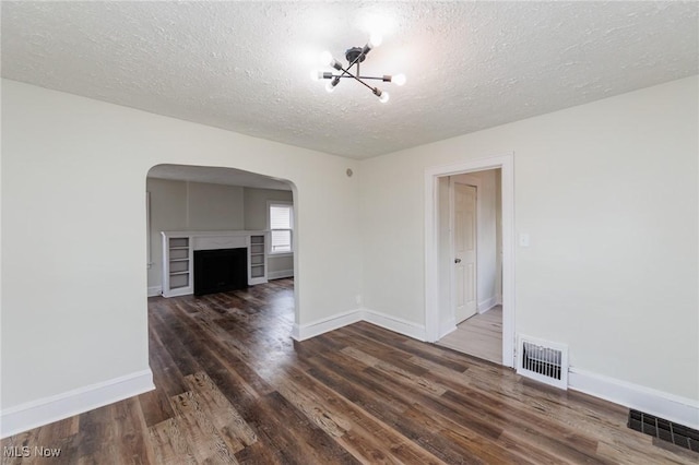 spare room with dark hardwood / wood-style flooring and a textured ceiling