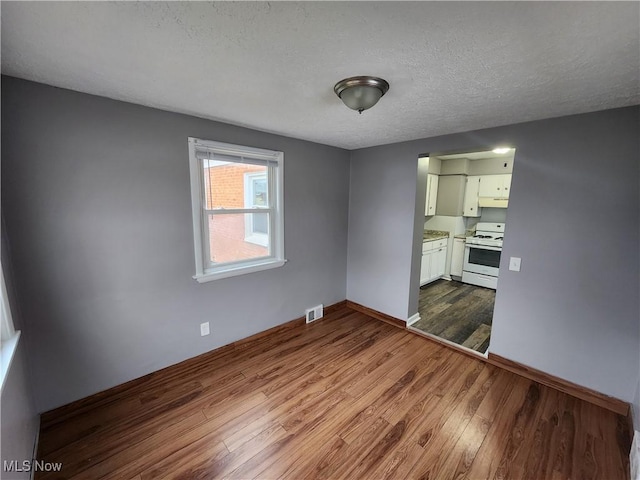 interior space with a textured ceiling and light hardwood / wood-style floors