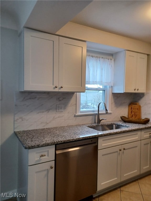 kitchen featuring sink, backsplash, dishwasher, and light tile patterned flooring