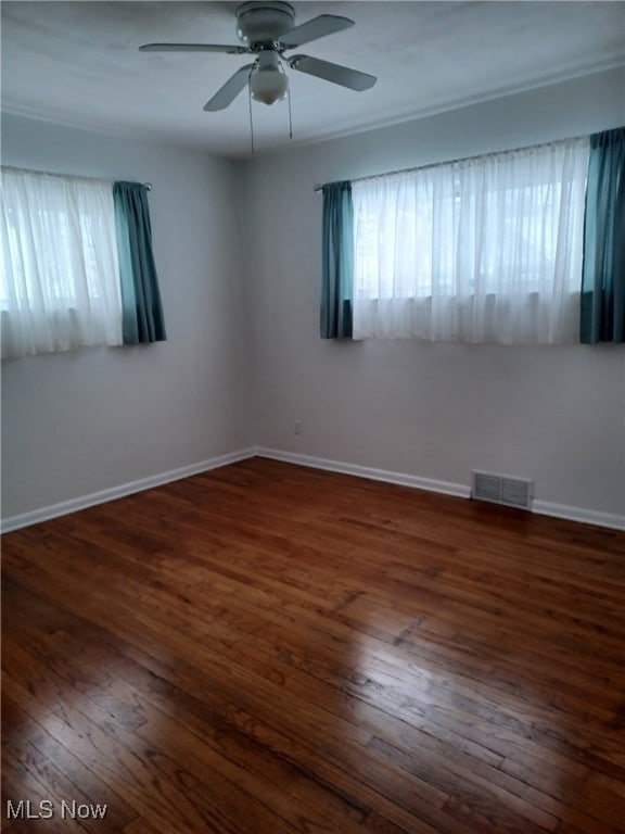 spare room with dark hardwood / wood-style flooring and a wealth of natural light