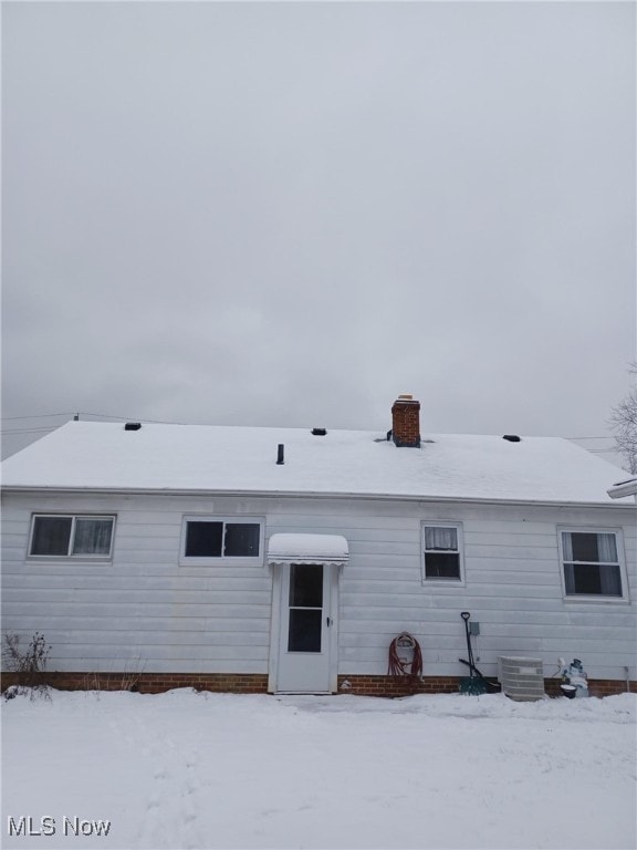 view of snow covered rear of property