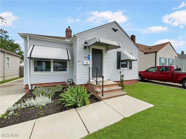 bungalow-style home featuring a front yard