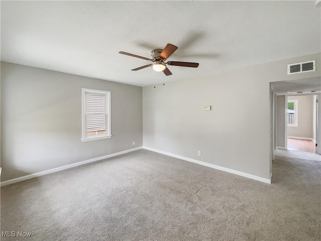 empty room featuring carpet, a textured ceiling, and ceiling fan