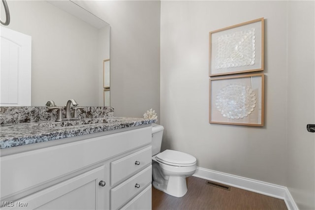 bathroom with vanity, wood-type flooring, and toilet