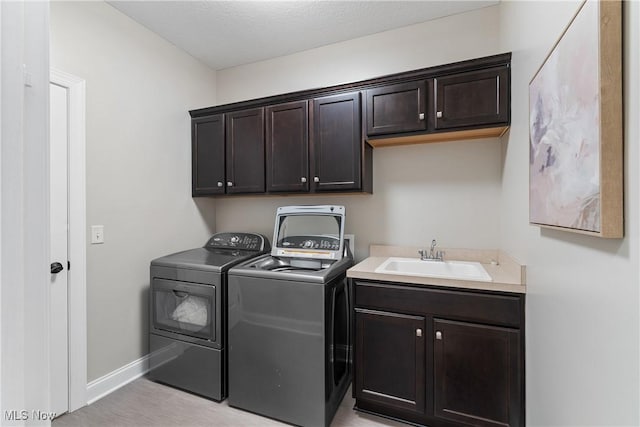 laundry area featuring cabinets, sink, and independent washer and dryer