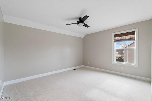 spare room with light carpet, vaulted ceiling, and ceiling fan