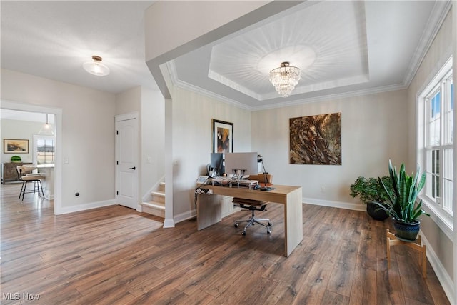 office space featuring a notable chandelier, a tray ceiling, and hardwood / wood-style flooring