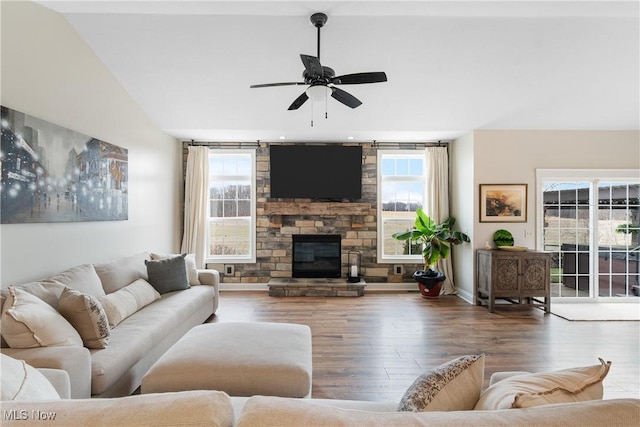 living room with a fireplace, dark wood-type flooring, and ceiling fan