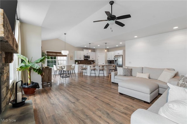 living room featuring hardwood / wood-style flooring, vaulted ceiling, and ceiling fan