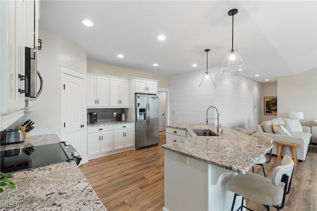 kitchen featuring pendant lighting, sink, white cabinets, and appliances with stainless steel finishes