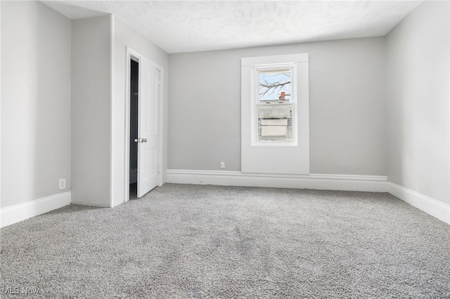 unfurnished room with a textured ceiling and carpet