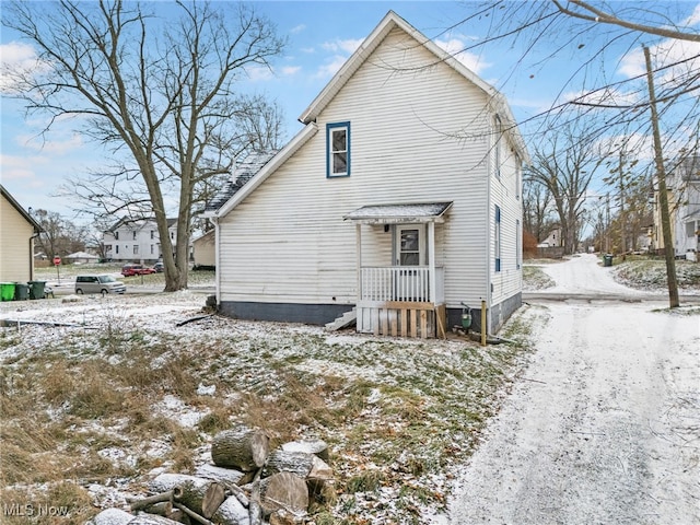 view of snow covered back of property