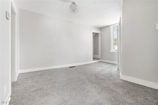 spare room with a textured ceiling and carpet