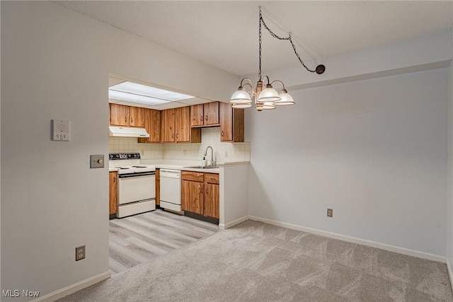 kitchen with decorative light fixtures, sink, backsplash, light colored carpet, and white appliances