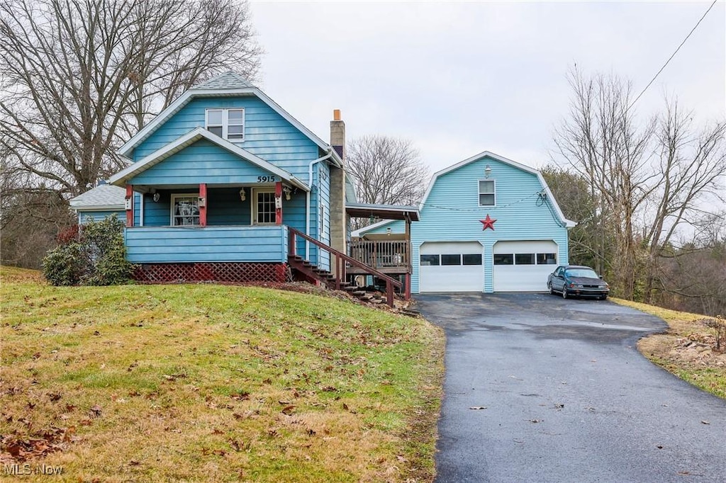 bungalow with a garage, a front yard, and a porch