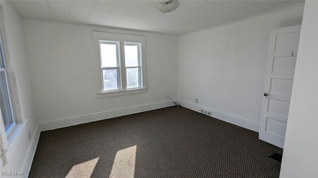 unfurnished room with dark carpet