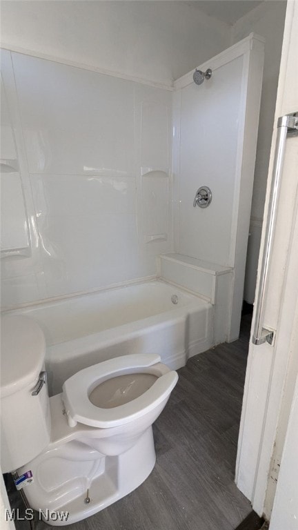 bathroom with hardwood / wood-style floors, shower / tub combination, and toilet