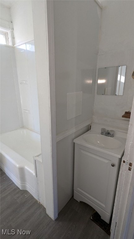 bathroom with hardwood / wood-style flooring, vanity, and a bathtub