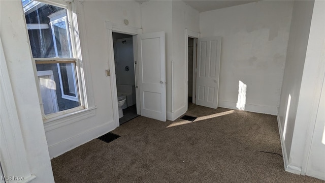 unfurnished bedroom with dark colored carpet