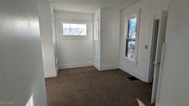 interior space with dark carpet and a textured ceiling