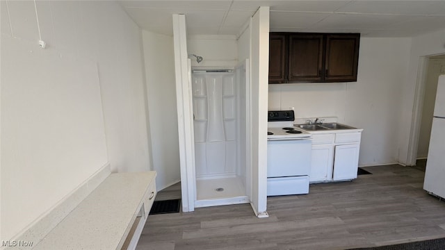 kitchen featuring dark brown cabinets, sink, white appliances, and light hardwood / wood-style floors