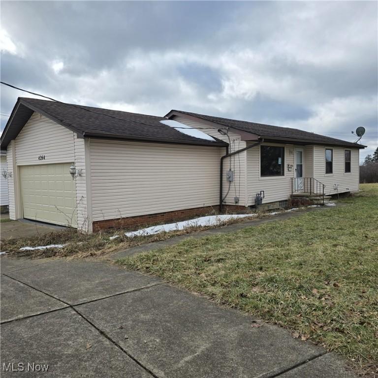 view of home's exterior featuring a garage and a yard