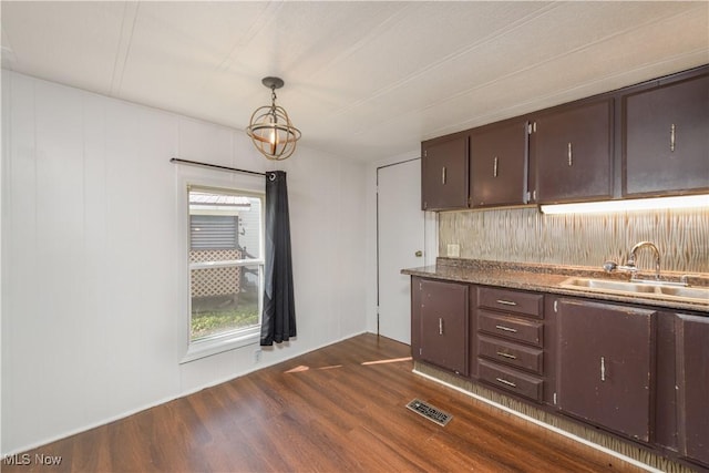 kitchen with sink, decorative light fixtures, dark brown cabinets, and dark hardwood / wood-style floors