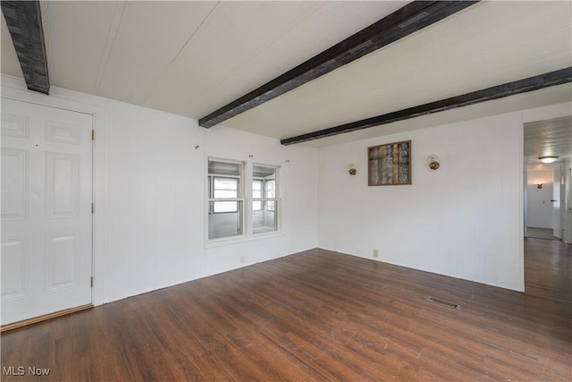 unfurnished room with beamed ceiling and dark hardwood / wood-style flooring