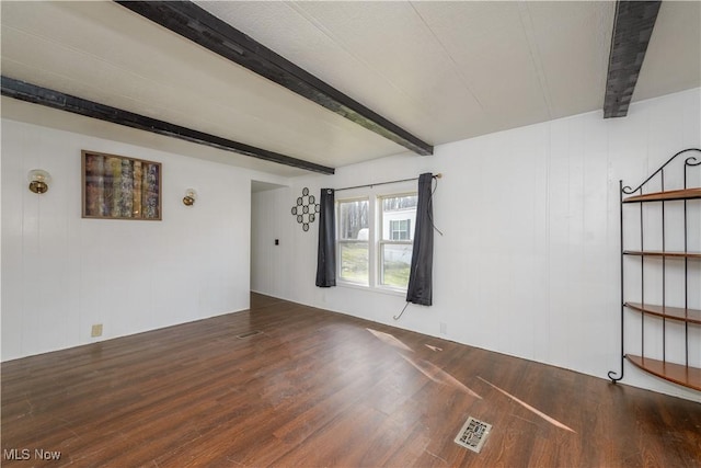 unfurnished room featuring beamed ceiling and hardwood / wood-style floors