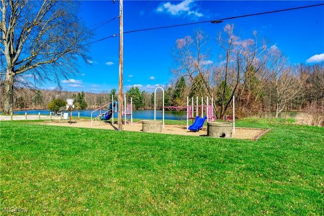 view of playground with a water view and a lawn