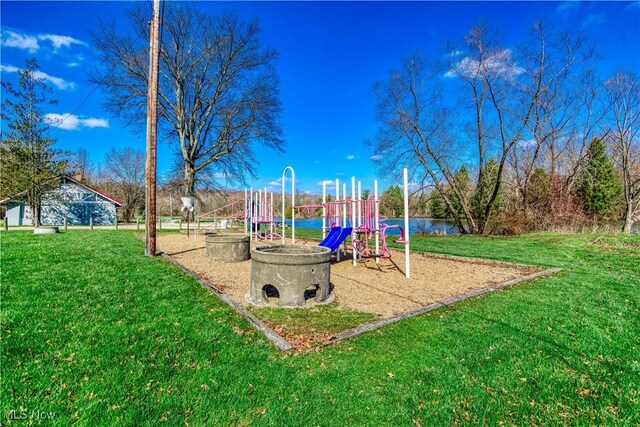 view of jungle gym with a yard and a water view