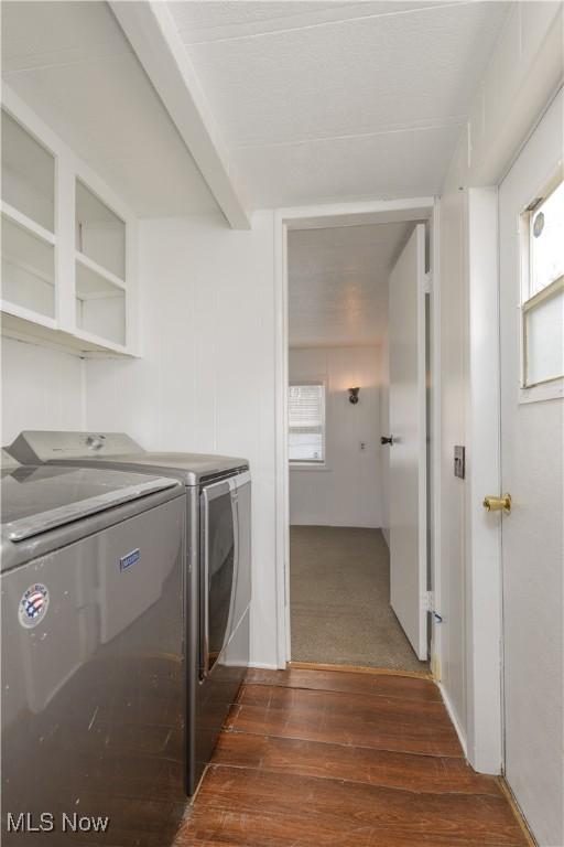 washroom with dark hardwood / wood-style floors and washing machine and dryer