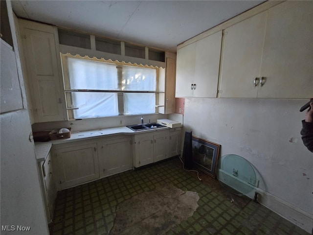 kitchen featuring white cabinetry and sink