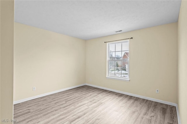 unfurnished room featuring light hardwood / wood-style flooring and a textured ceiling