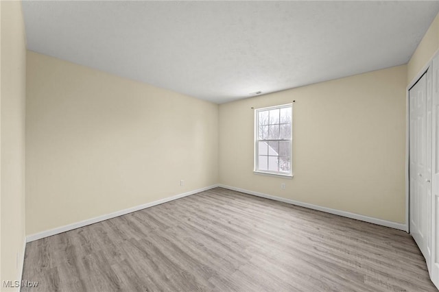 unfurnished bedroom featuring light wood-type flooring and a closet