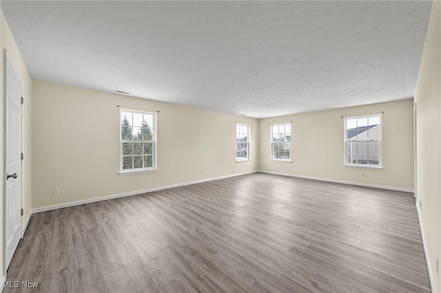 unfurnished room with wood-type flooring and a textured ceiling