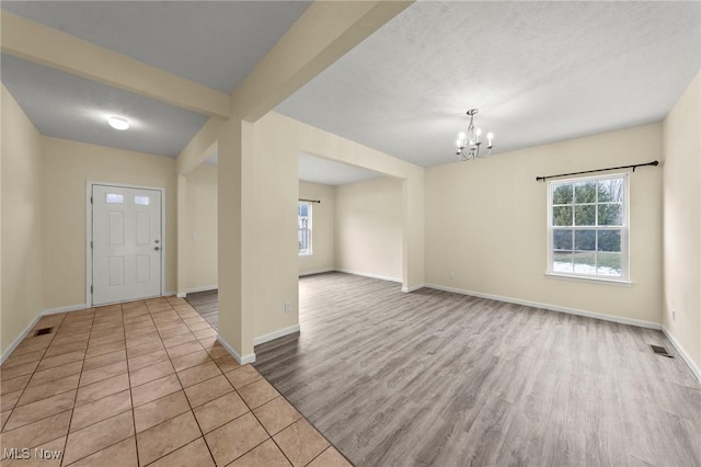 foyer entrance with a notable chandelier and light hardwood / wood-style floors