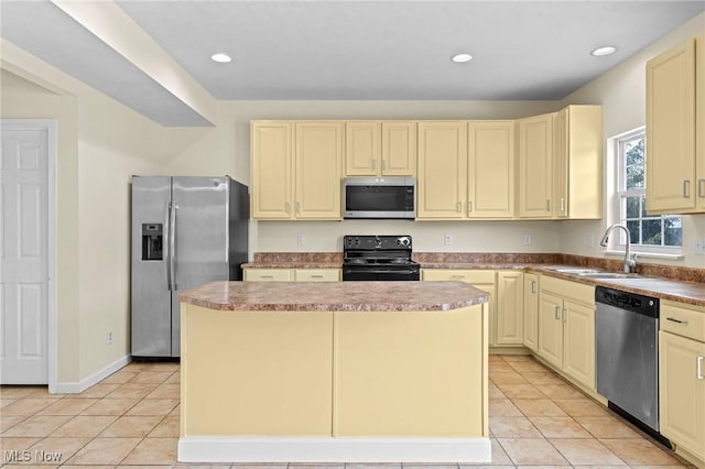 kitchen featuring sink, cream cabinets, stainless steel appliances, and a kitchen island