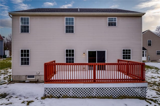 snow covered rear of property featuring a deck