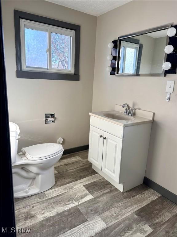 bathroom with vanity, hardwood / wood-style floors, a textured ceiling, and toilet