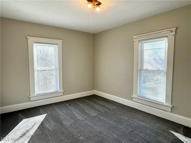 carpeted empty room with a textured ceiling